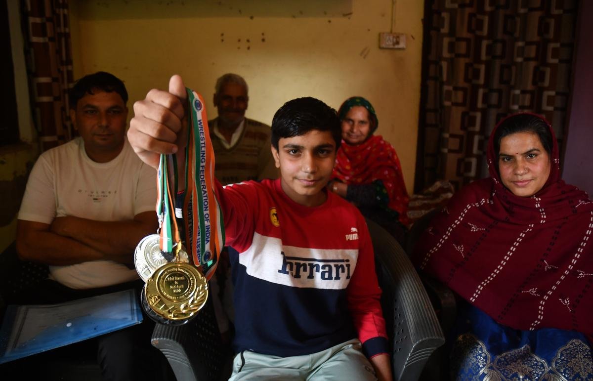 Khushi (centre) shows her medals, with her family around her: father Ajay Kumar, mother Sharda Devi, and grandparents (behind).