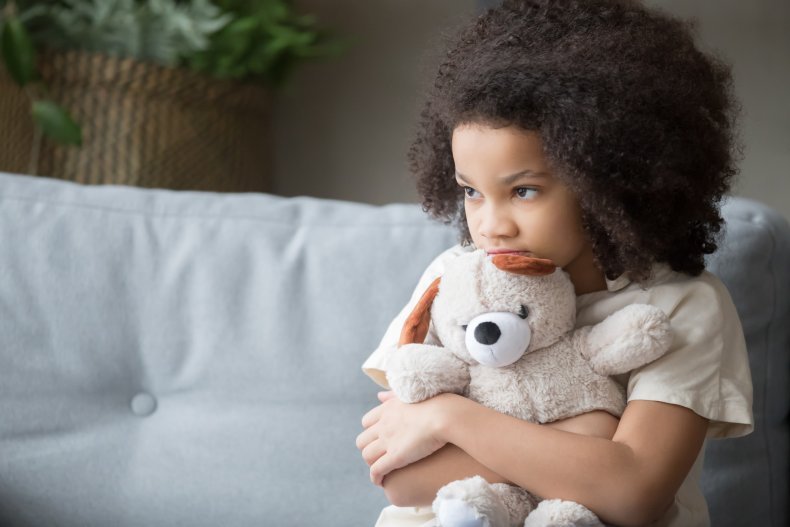 An upset little girl cuddling a teddy