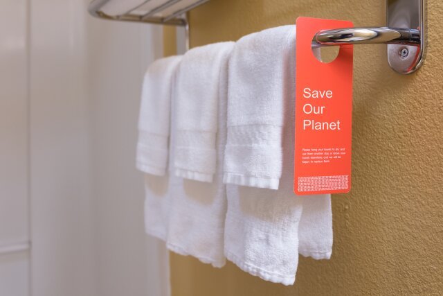 "Save water" sign on a hotel towel bar to encourage reuse of bath towels