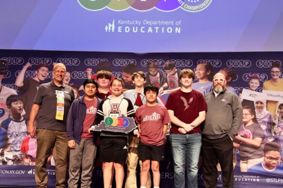 Picture of a group of six students on stage holding an STLP trophy, standing beside two Kentucky Department of Education staff members.