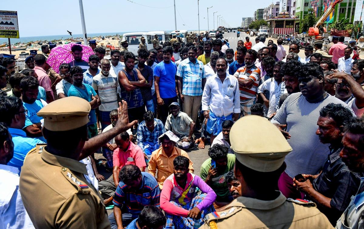 Police personnel talking with the protesting fishermen and residents of nearby localities on Loop Road in Chennai.