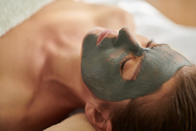 Woman with exfoliating clay mask on face.